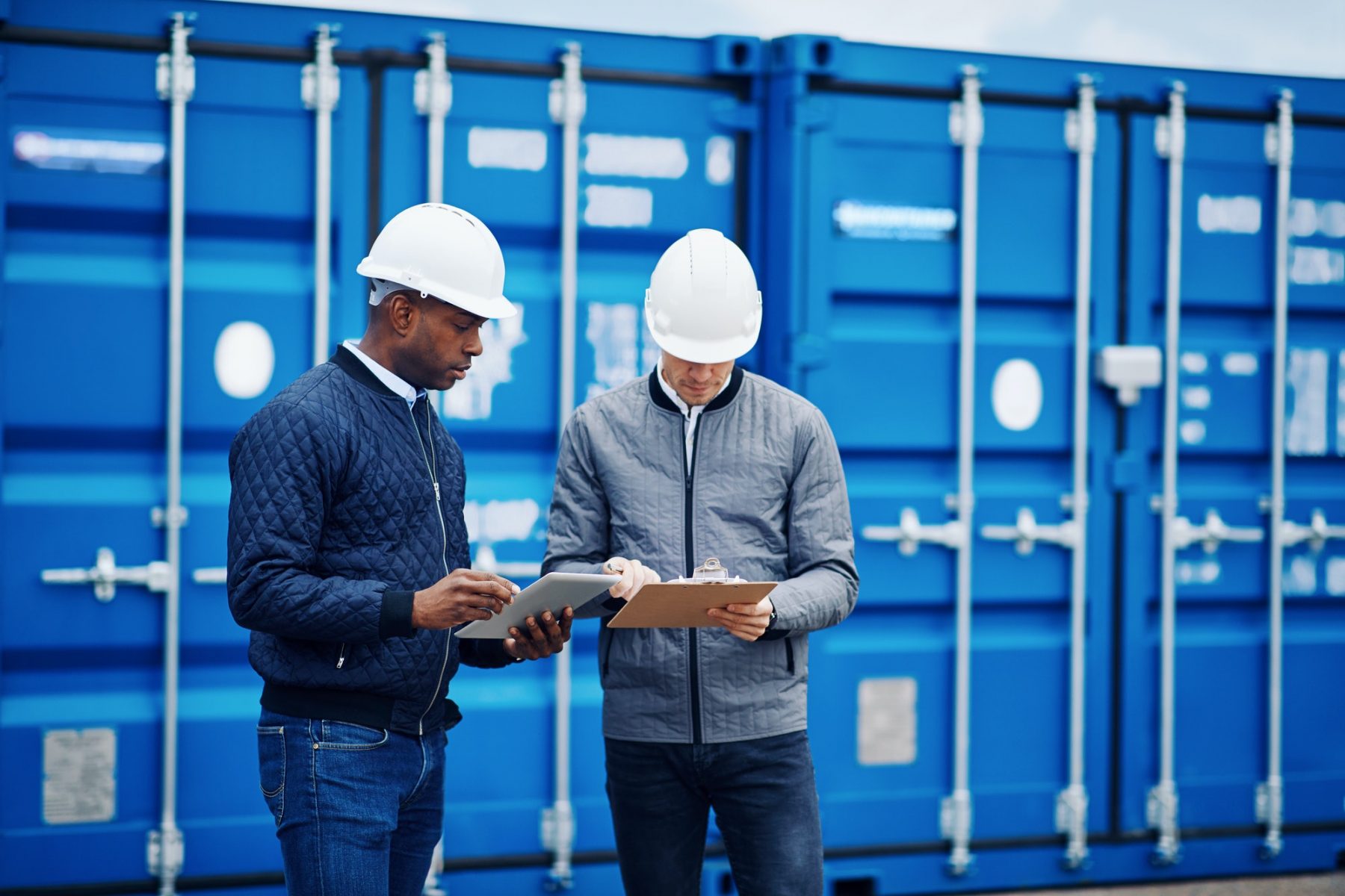 Two engineers tracking containers in a freight yard