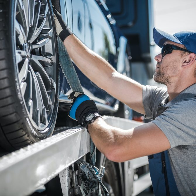 Towing Truck Driver Securing Transported Vehicle